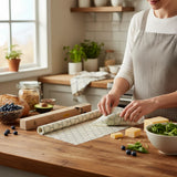 SuperBee Australia beeswax wrap roll with a hexagonal pattern being used to wrap food in a bright, rustic kitchen.