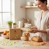 SuperBee Australia Beeginner Set beeswax wraps with fruit patterns covering a jar and bread on a kitchen counter.