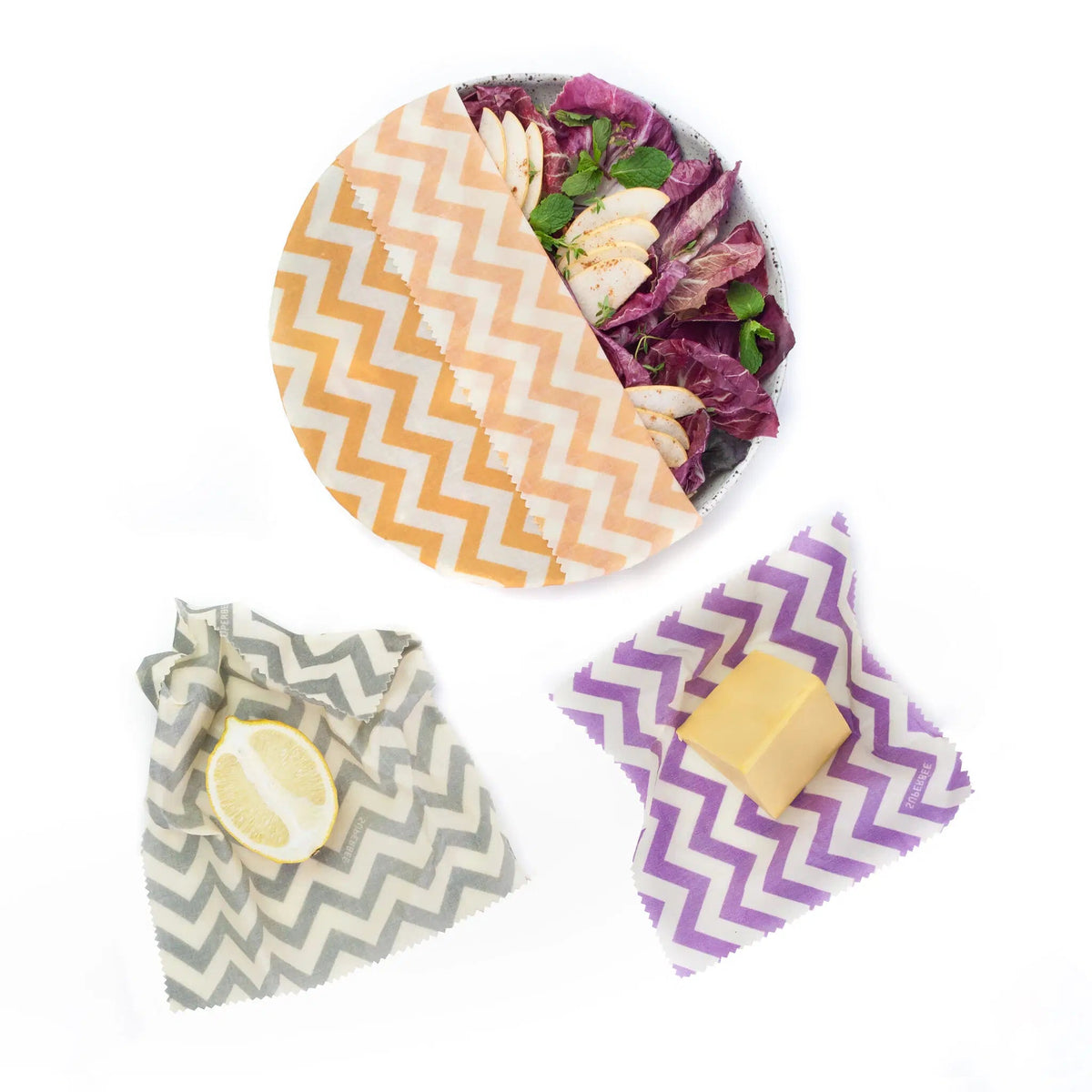 SuperBee Australia Beeginner Set of three beeswax wraps in zig zag patterns covering a salad, lemon, and cheese block.