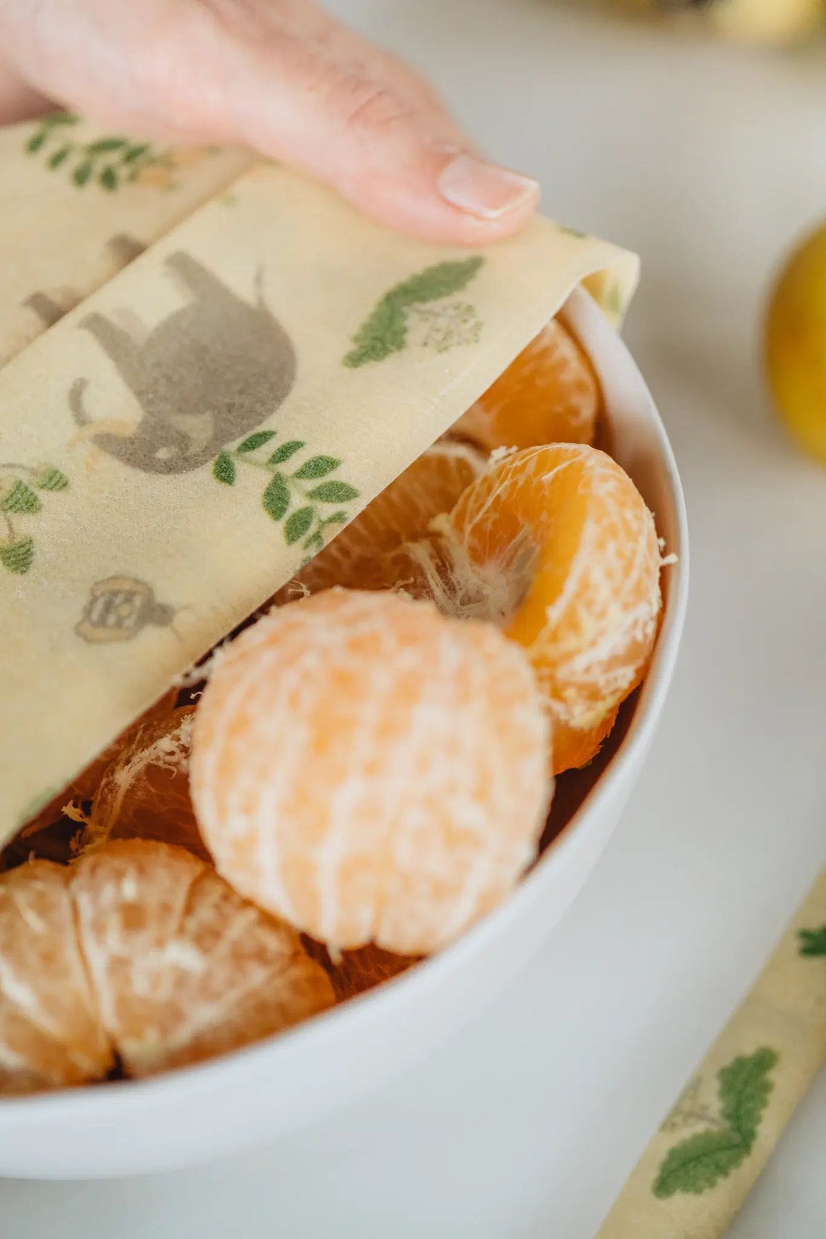 SuperBee Australia beeswax wrap with elephant print covering a white bowl filled with fresh mandarin segments