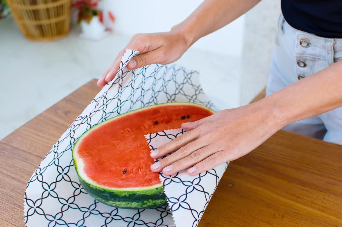 SuperBee Australia extra large reusable beeswax wrap with black and white meadow pattern covering half a watermelon