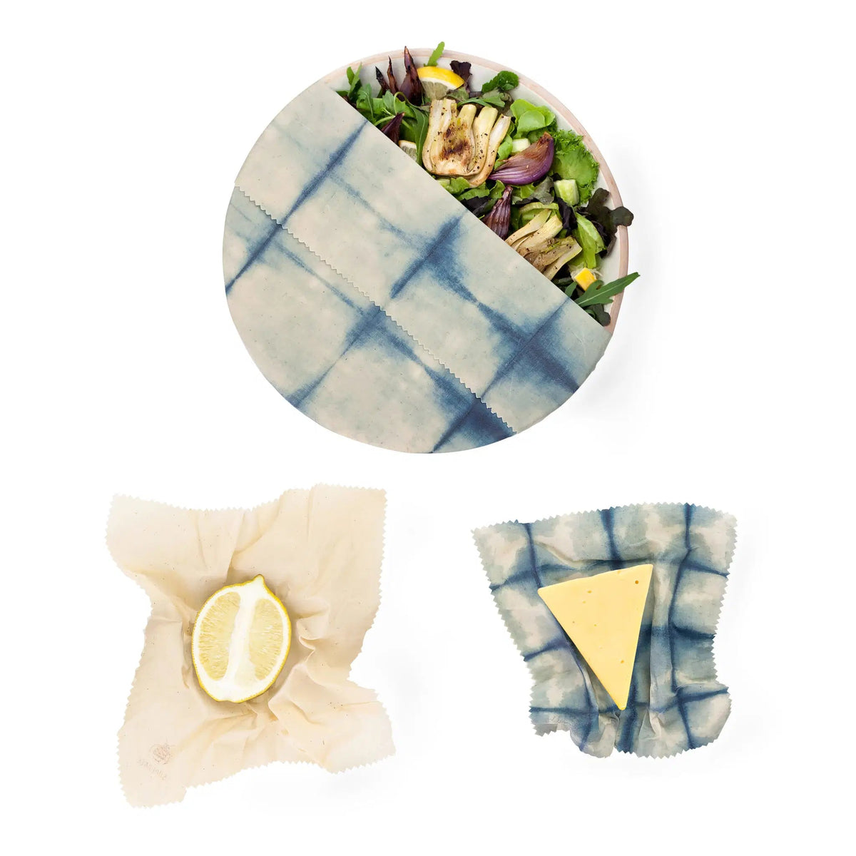 SuperBee Australia Beeginner Set indigo beeswax wraps covering a salad bowl, a lemon half, and a wedge of cheese.