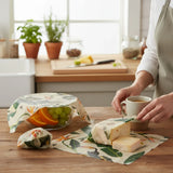SuperBee Australia beeswax wraps in Jungle print covering a bowl of fruit and cheese on a wooden kitchen table.