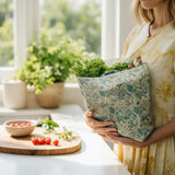 SuperBee Australia large reusable beeswax food storage bag in sea floor print, held by a woman in a kitchen.