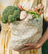 SuperBee Australia medium beeswax food storage bag with a cream and green hexagon pattern filled with fresh vegetables