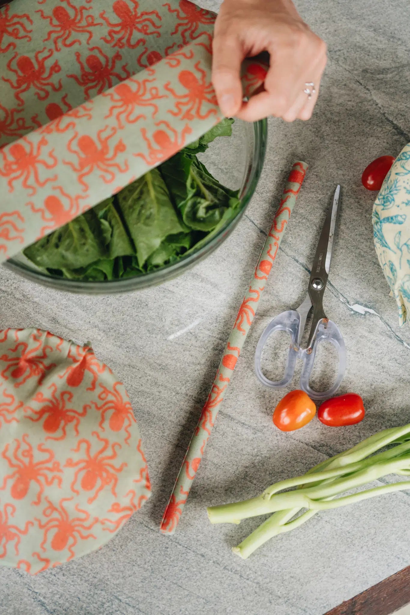 SuperBee Australia beeswax wrap roll with orange octopus print covering a bowl of greens on a kitchen counter