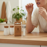 SuperBee Australia plastic-free dental floss made from organic corn fibre in a glass dispenser on a wooden table.