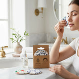 SuperBee Australia reusable makeup remover pads in patterned cotton, held by a woman in a bright bathroom setting.