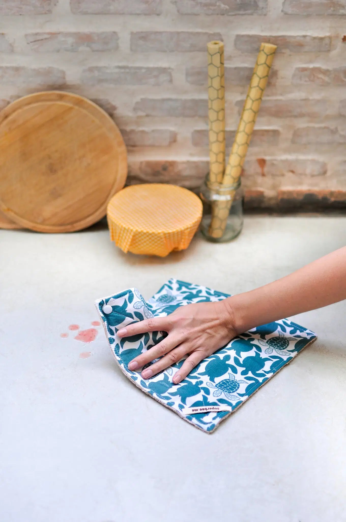 SuperBee Australia reusable organic cotton kitchen towel with turtle print cleaning a spill on a countertop