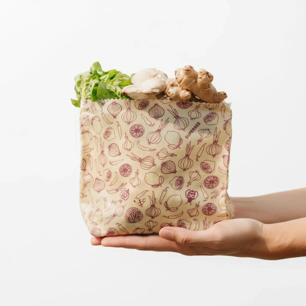 SuperBee Australia small beeswax food storage bag with spicy vegetable print, held in hands filled with fresh produce